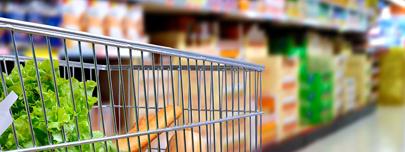 Grocery cart against supermarket shelves